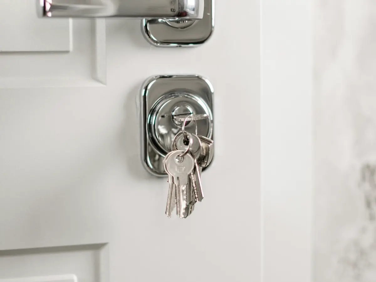 Molho de chaves pendurado na fechadura de uma porta branca